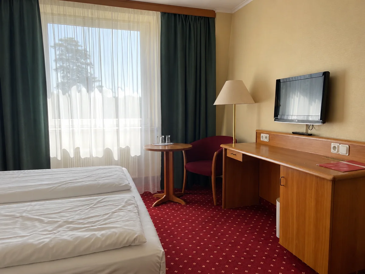 Standard-Doppelzimmer mit Schreibtisch, Sitzecke und großem Fenster im Hotel Rosenstadt