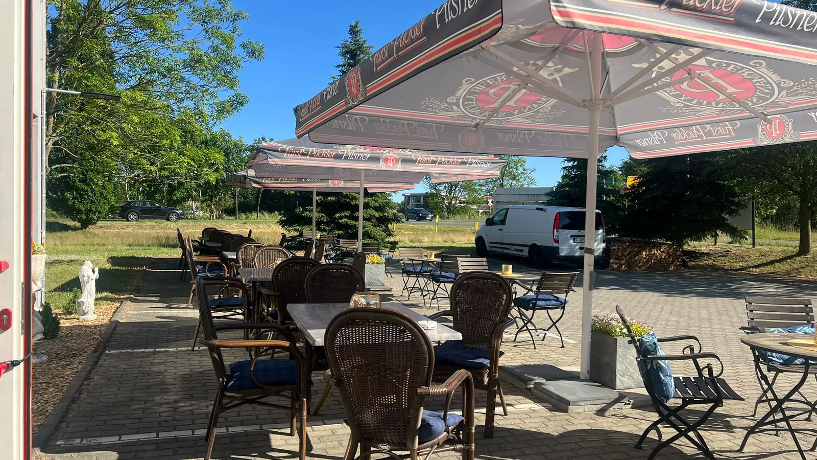 Sitzplätze unter Sonnenschirmen im Biergarten des Stadtgesprächs